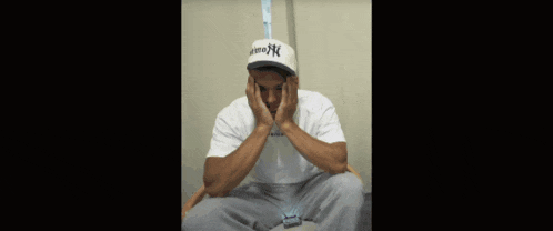 a man wearing a hurley hat is sitting down