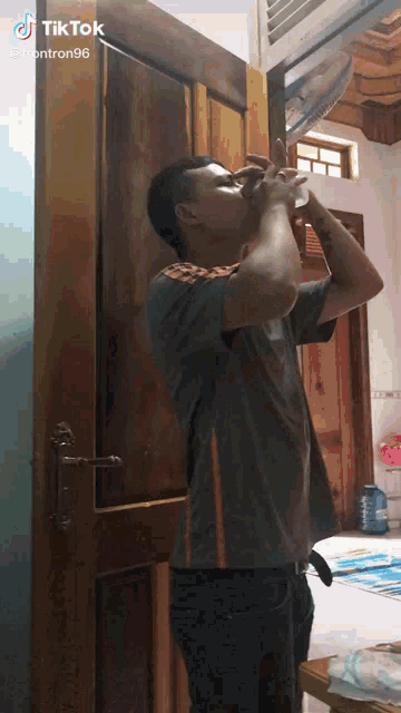 a man drinking from a bottle with a tiktok watermark