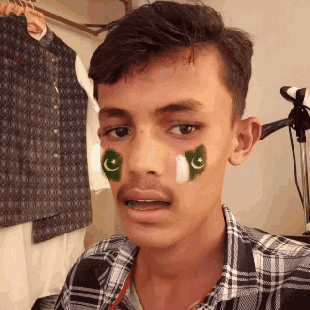 a young man with a green and white flag on his face