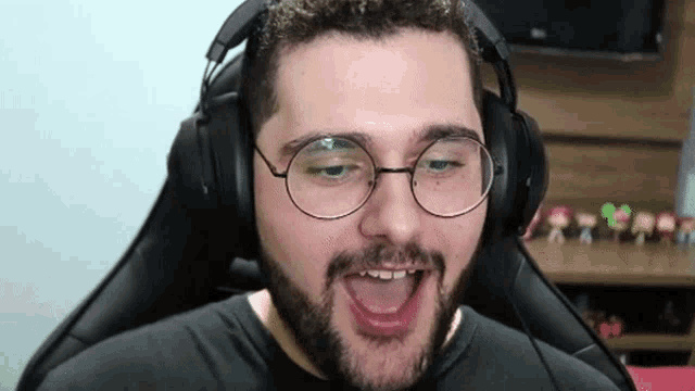 a man with a beard and glasses is wearing headphones and making a funny face