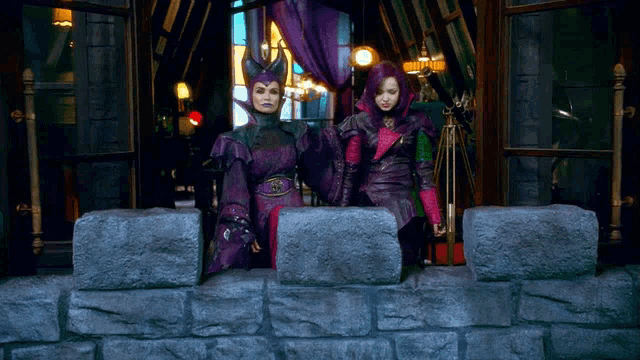a woman in a purple dress is standing next to another woman