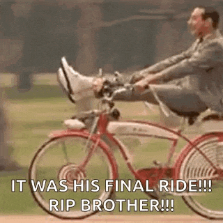 a man in a suit is riding a bicycle with his feet up in the air .