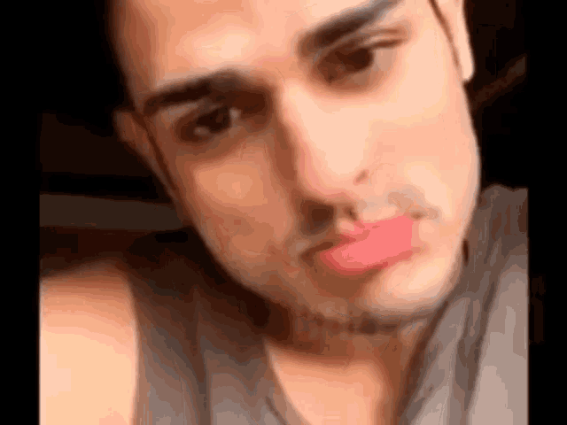 a close up of a man 's face with lipstick on his lips .