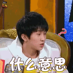 a young man sitting on a couch with a question mark on his head