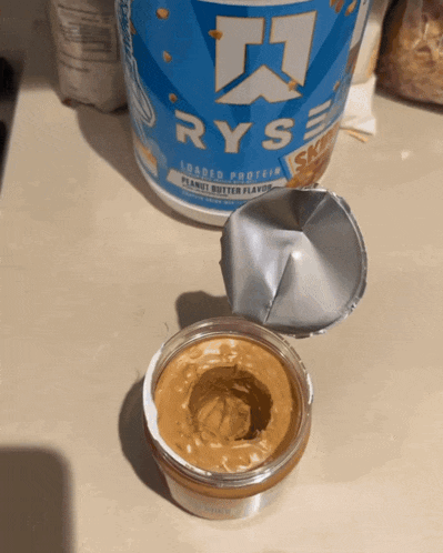 a jar of peanut butter sits next to a container of ryse protein