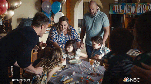 a group of people are gathered around a table with balloons and a sign that says the new big 2