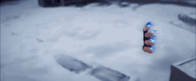 a person is holding a blue object in their hand in the snow