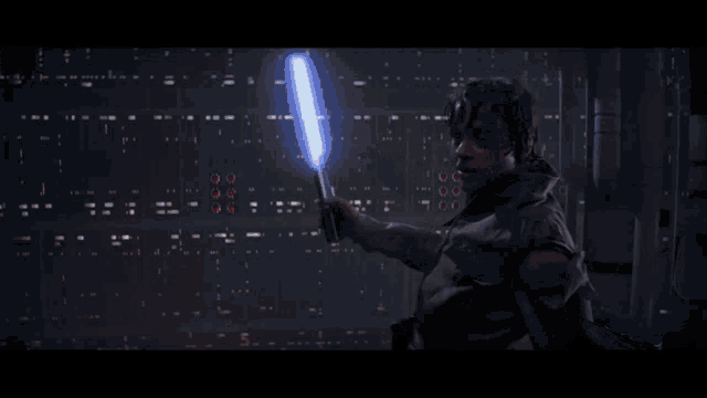 a man is holding a red and green lightsaber in his hand