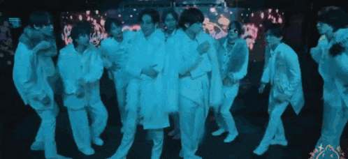 a group of people in white clothes are dancing together