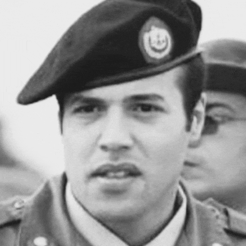 a black and white photo of a man in a military uniform wearing a black beret .