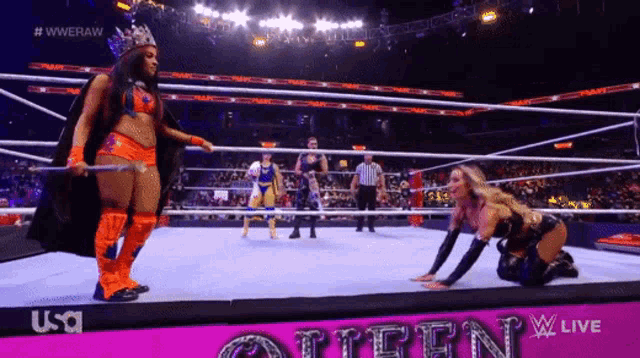 a woman is kneeling down in a wrestling ring with the word queen on the bottom