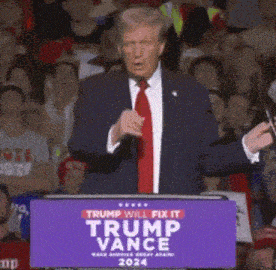 a man in a suit and tie stands behind a trump vance sign