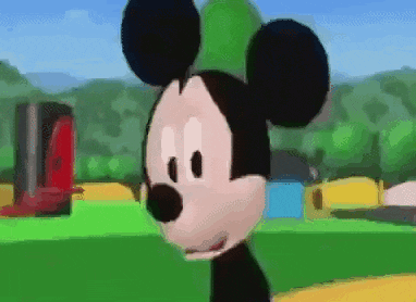 a close up of mickey mouse 's face with a green field in the background