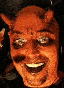 a man with devil horns on his head is smiling