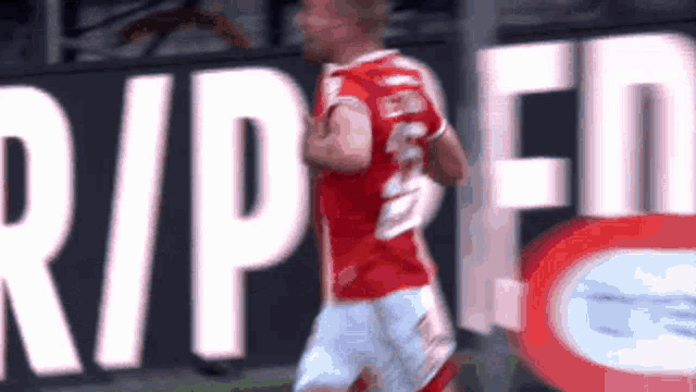 a soccer player is running in front of a sign that says rip en