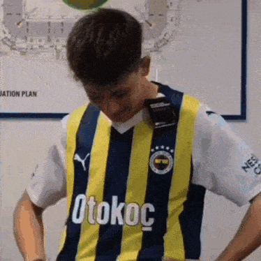 a young man wearing a yellow and blue striped shirt with the word otokoc on it