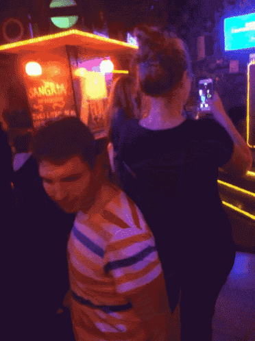 a man in a striped shirt is standing next to a woman