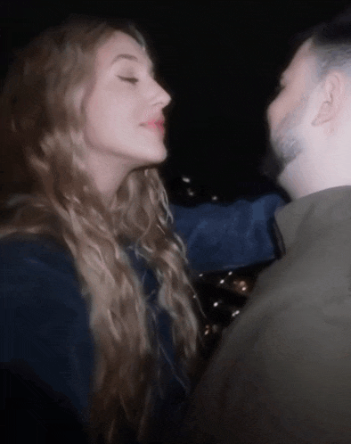 a man and woman are kissing in the dark