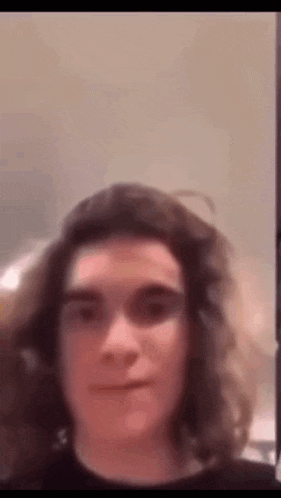a man with long hair is making a funny face .