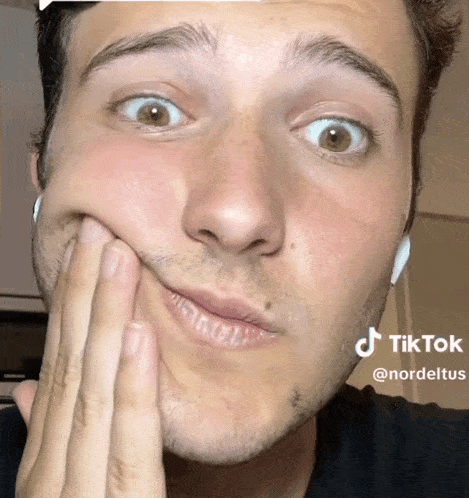 a close up of a man 's face with a tiktok sticker on the bottom