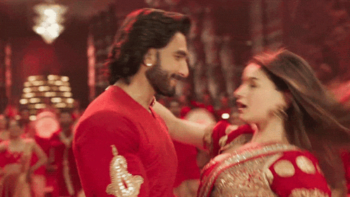 a man and a woman are dancing together in a red room