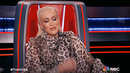 a woman in a leopard print dress is sitting in a chair with a nbc logo on the bottom