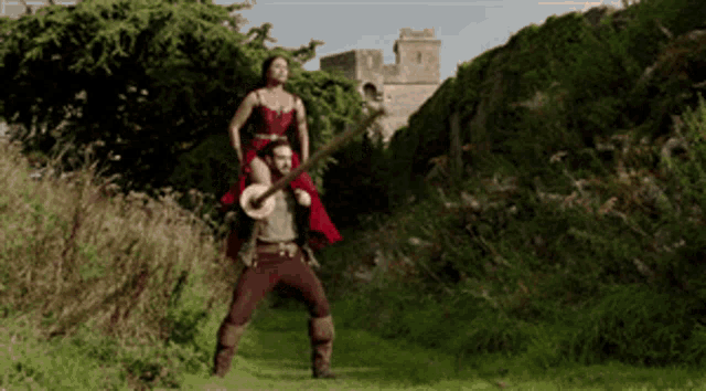 a man carrying a woman on his shoulders while holding a guitar