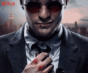 a man in a suit and tie is wearing sunglasses and a bloody hand .