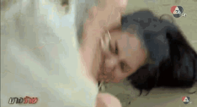 a woman is laying on the ground with her head on a man 's lap .