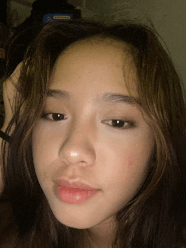 a close up of a girl 's face with a blue box behind her that says ' nintendo ' on it