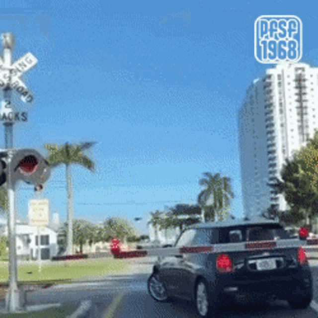 a car is driving past a railroad crossing with the year 1968 on the bottom