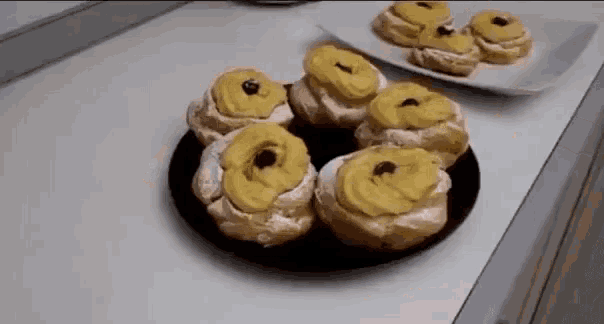 a plate of pastries with yellow frosting on a table