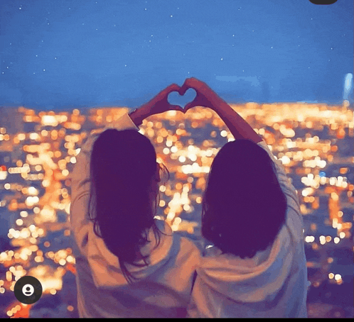 two women make a heart shape with their hands