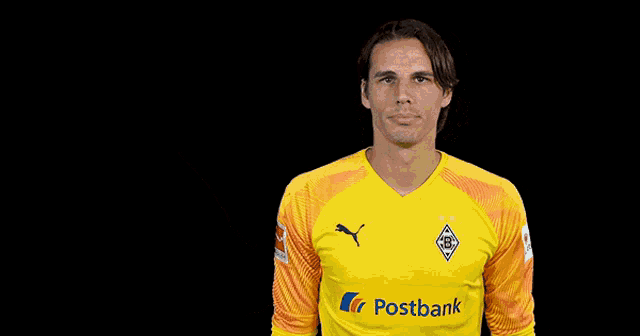a soccer player wearing a yellow postbank jersey