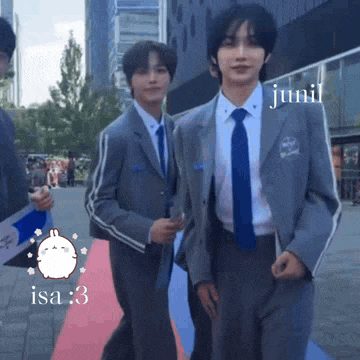 two men in suits and ties are walking on a red carpet