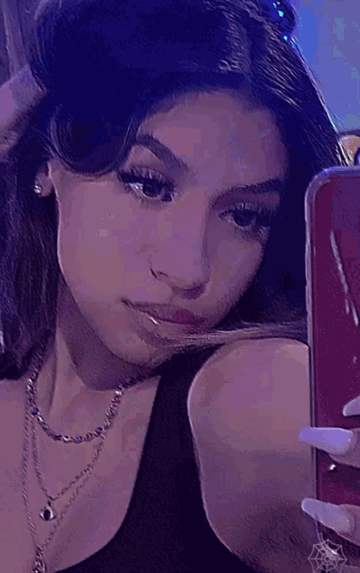 a girl taking a picture of herself in the mirror