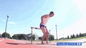 a man jumping over a hurdle on a track with chinese writing