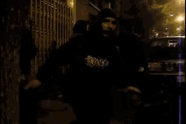 a man wearing a black shirt that says ' sickness ' on it