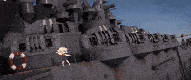 a little girl is standing on the deck of a large ship .