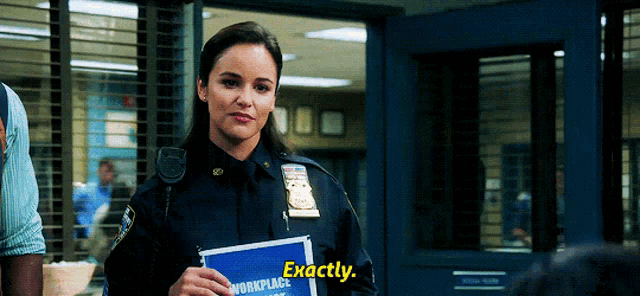 a woman in a police uniform is holding a blue sign that says exactly