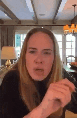 a woman is making a funny face in a living room while talking on a video call .