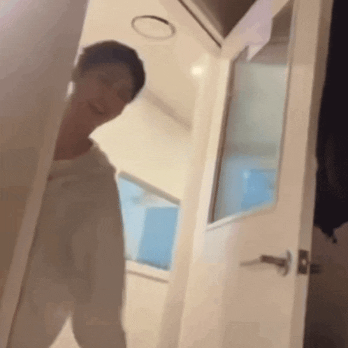 a man is standing in a doorway with a towel on his shoulders .