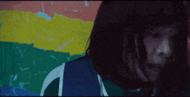 a woman with a rainbow flag behind her