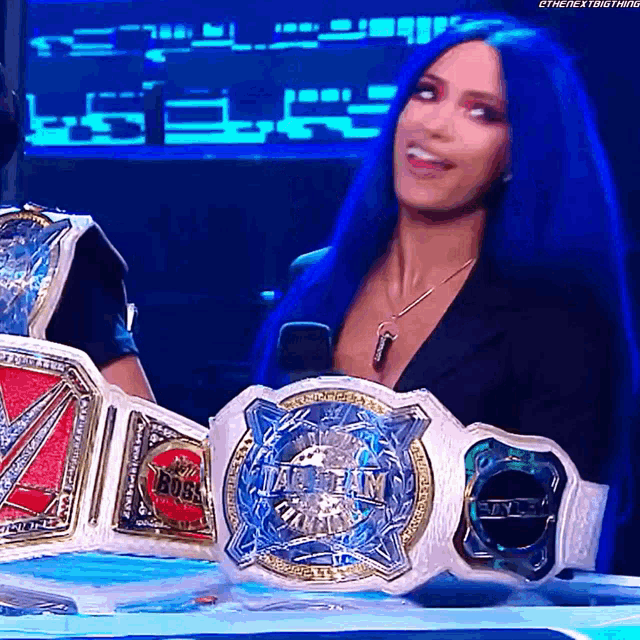 a woman with blue hair is holding a belt that says ' intercontinental ' on it