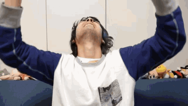 a man is sitting on a couch with his arms outstretched and looking up .