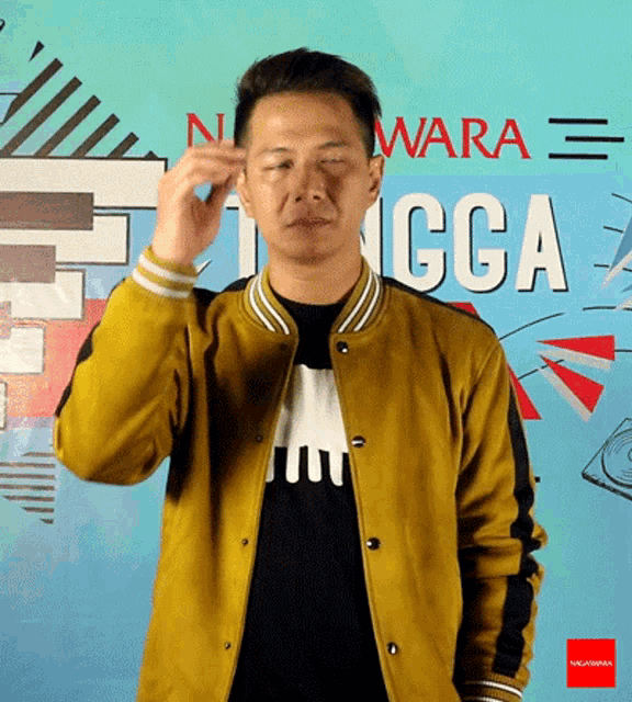a man wearing a yellow jacket stands in front of a wall that says ccga