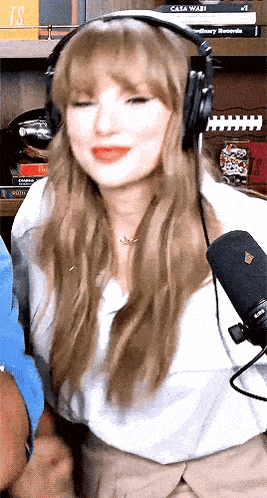 a woman wearing headphones and a microphone is smiling .