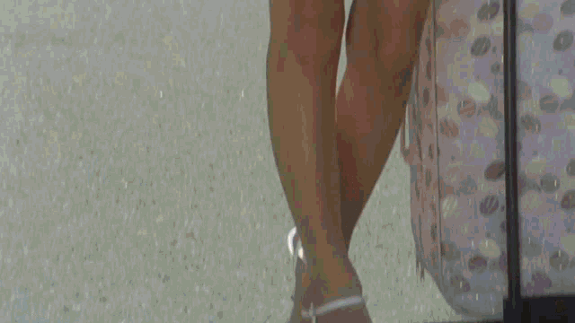 a woman in a blue skirt is walking with a suitcase in the background