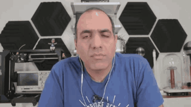 a man wearing headphones and a blue shirt that says bridge