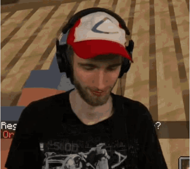 a man wearing headphones and a red hat with the letter c
